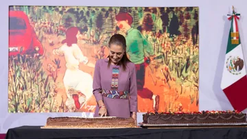 La presidenta Claudia Sheinbaum parte un pastel durante la celebración de su cumpleaños número 64 en Palacio Nacional.