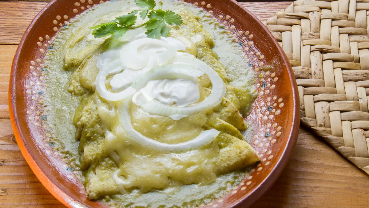 Las recetas enchiladas suizas nacieron en la CDMX y combinan el picante del chile verde con la suavidad del queso y la crema.