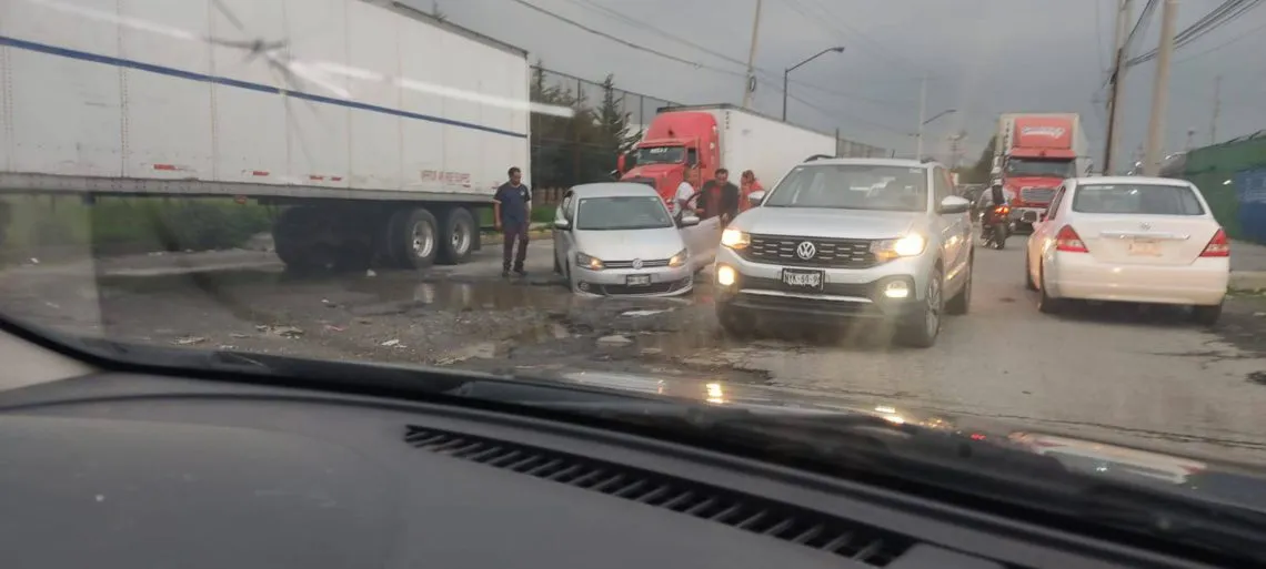 Toluca: Auto queda varado en bache de Industria Automotriz