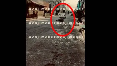 En este impactante material, se observa un auto blanco de marca Ford pasar frente a la cámara de una persona que grabó el instante en el que una mujer va siendo arrastrada bajo el carro. Foto: Captura