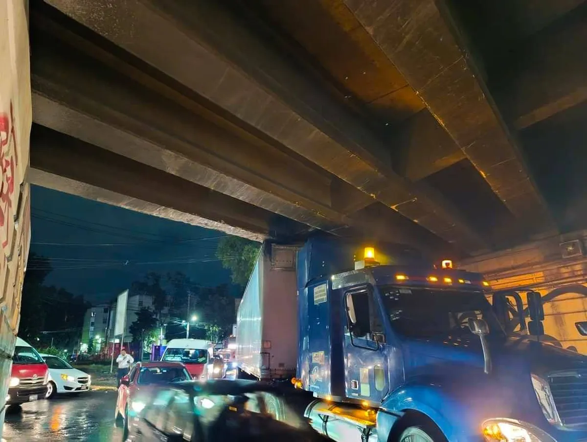 Tráiler se queda atascado en el bajo puente en Perinorte