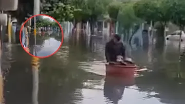 Con una tina, hombre ayuda a sus sobrinos a cruzar las calles inundadas de La Paz