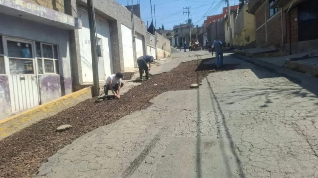 Vecinos de Ixtapaluca repavimentan calle con recursos propios