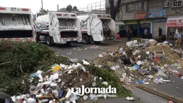 Trabajadores descargan camiones de basura sobre la Vía Morelos en Ecatepec