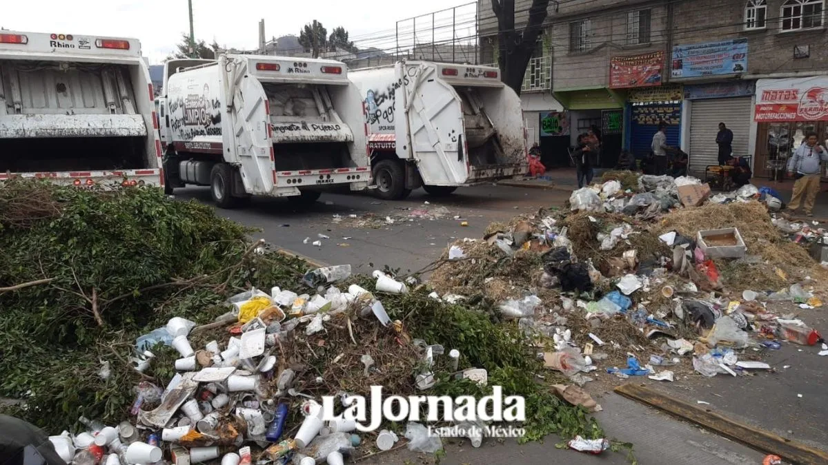 Trabajadores descargan camiones de basura sobre la Vía Morelos en Ecatepec