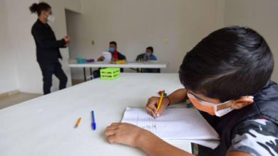 niño dibujando con cubrebocas en escuela particular guardando sana distancia