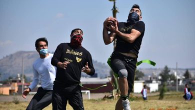 Jugadores de Lobos y Búhos jugando en campo, partido de fútbol americano