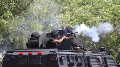 Policías estatales lanzando gas lacrimógeno contra estudiantes